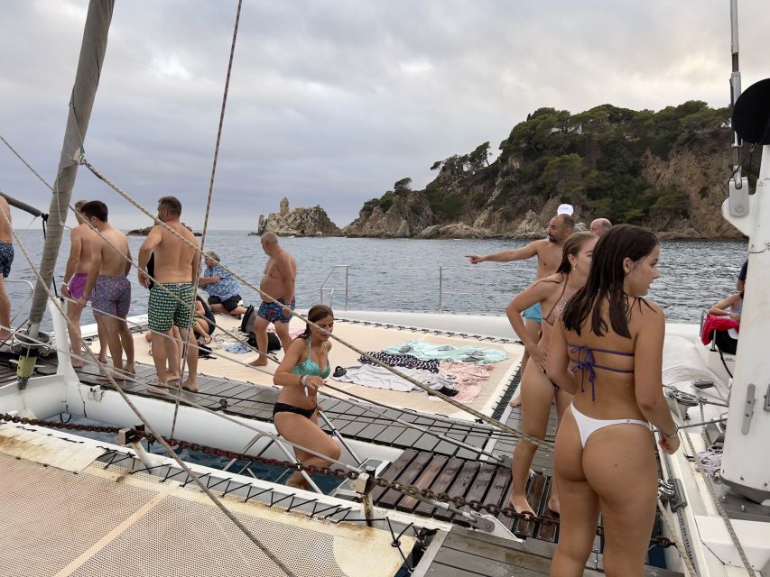 Lloret de Mar: Sunset Catamaran Cruise with DJ and Drinks - Cruise time on Costa Brava: rocky shore, homes close to the water